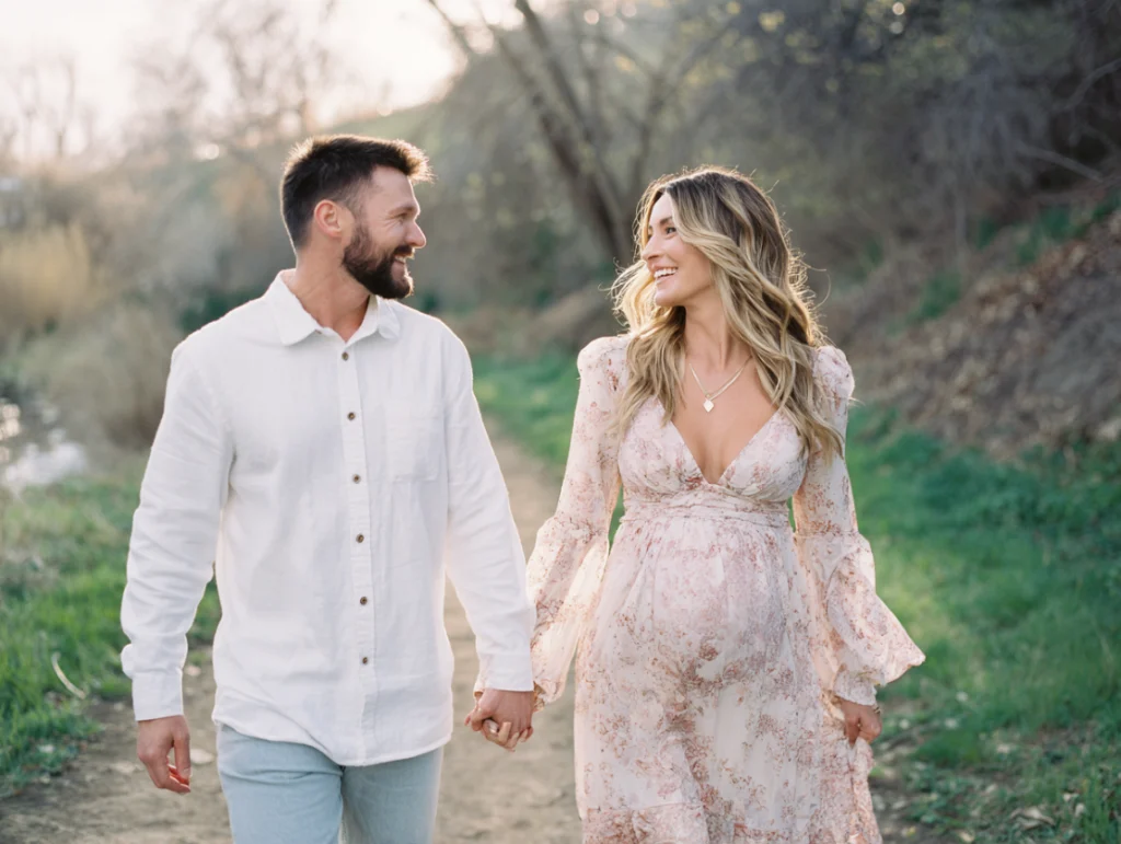 Photo of couple holding hands outdoors during a maternity photography session.