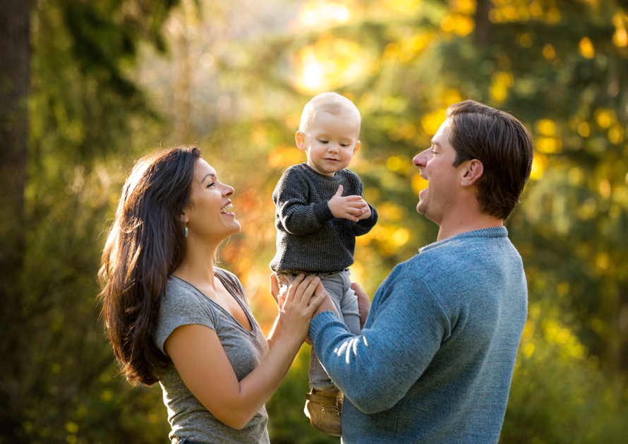 Happy couple holding their baby posing for a professional photoshoot in an outdoor session
