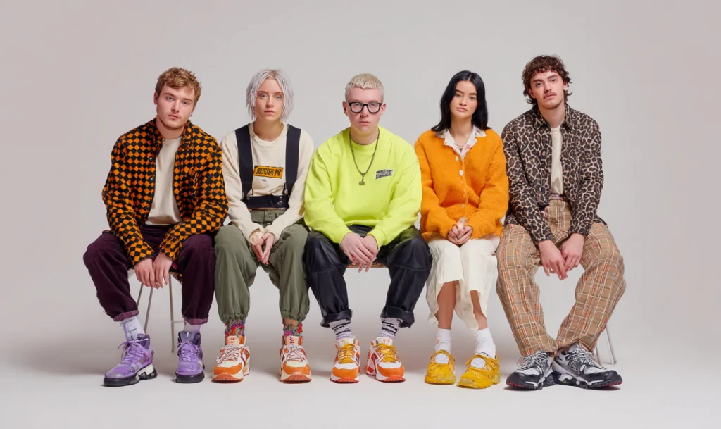 Studio family photo with five people wearing mismatched bright and patterned outfits, highlighting what not to wear for portraits.