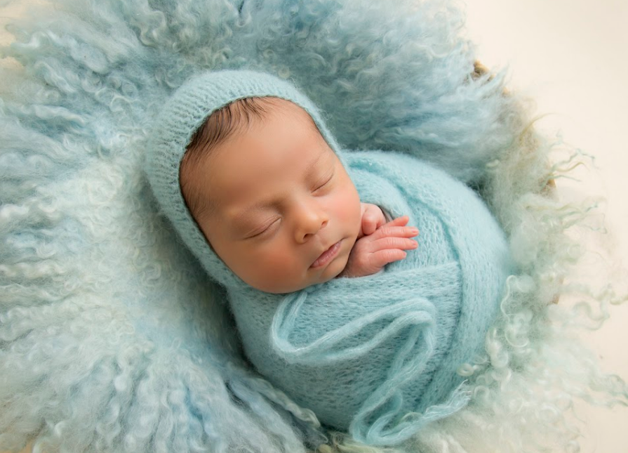 Newborn baby wrapped around a soft blanket