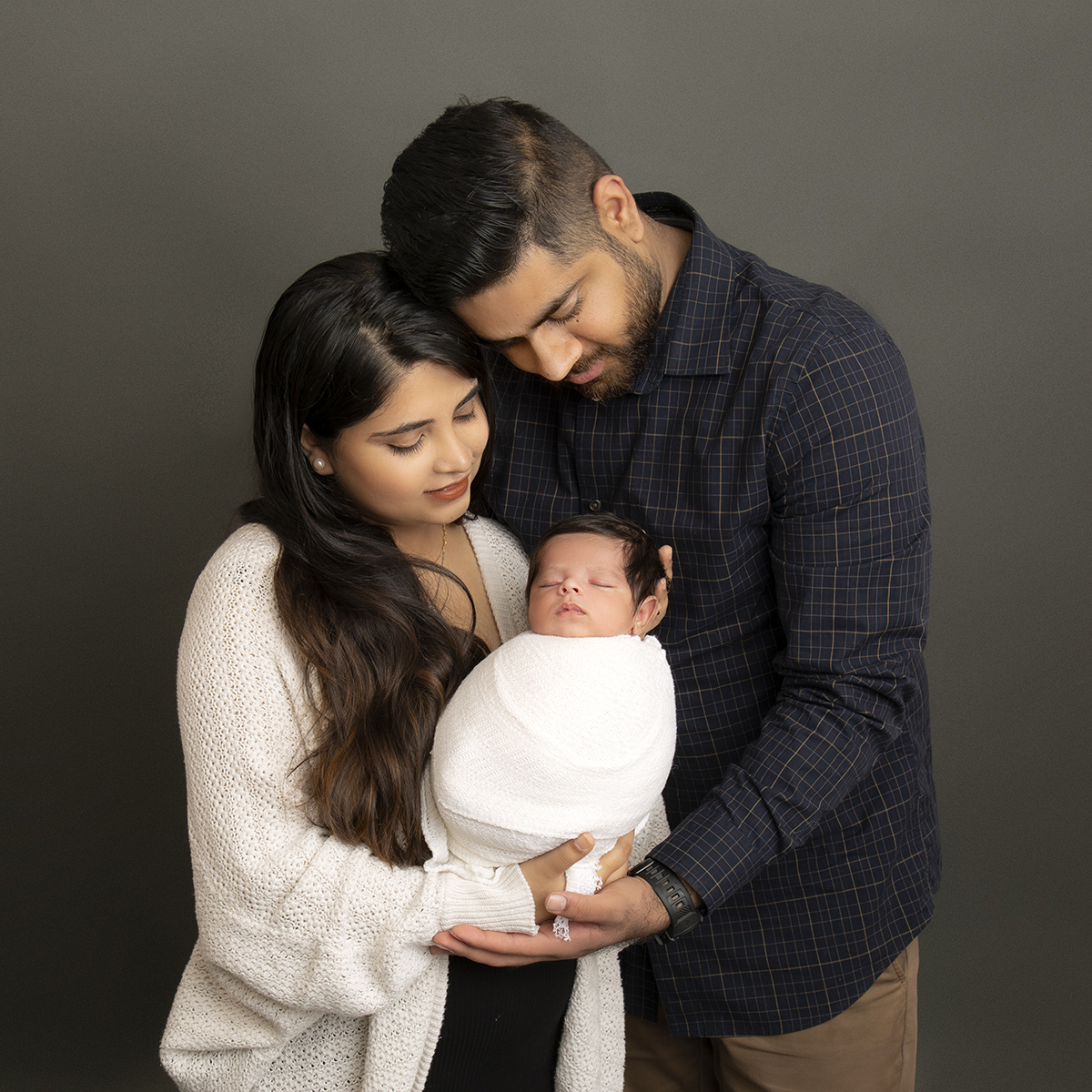 family holding baby at newborn photography surrey client at artin photography studio
