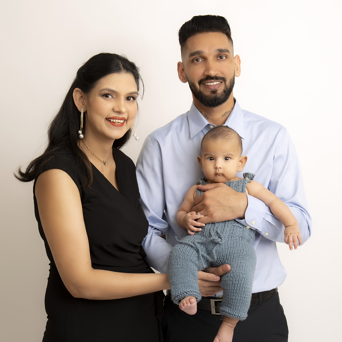 family holding baby pose at newborn photography surrey client at artin photography studio