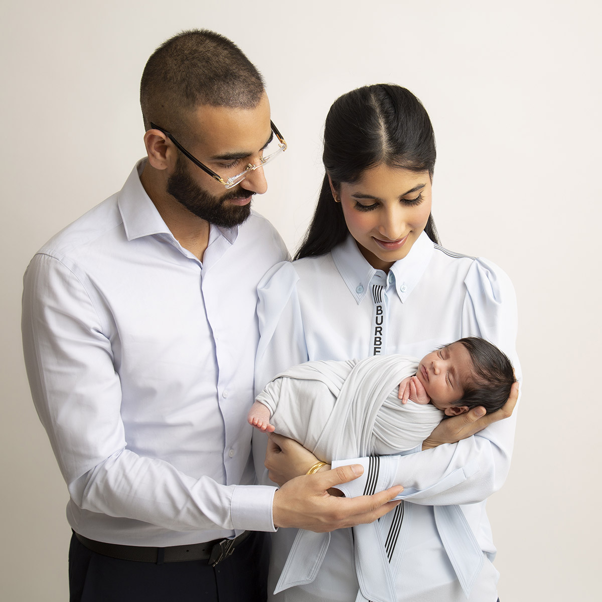 family holding baby at newborn photography surrey client at artin photography studio