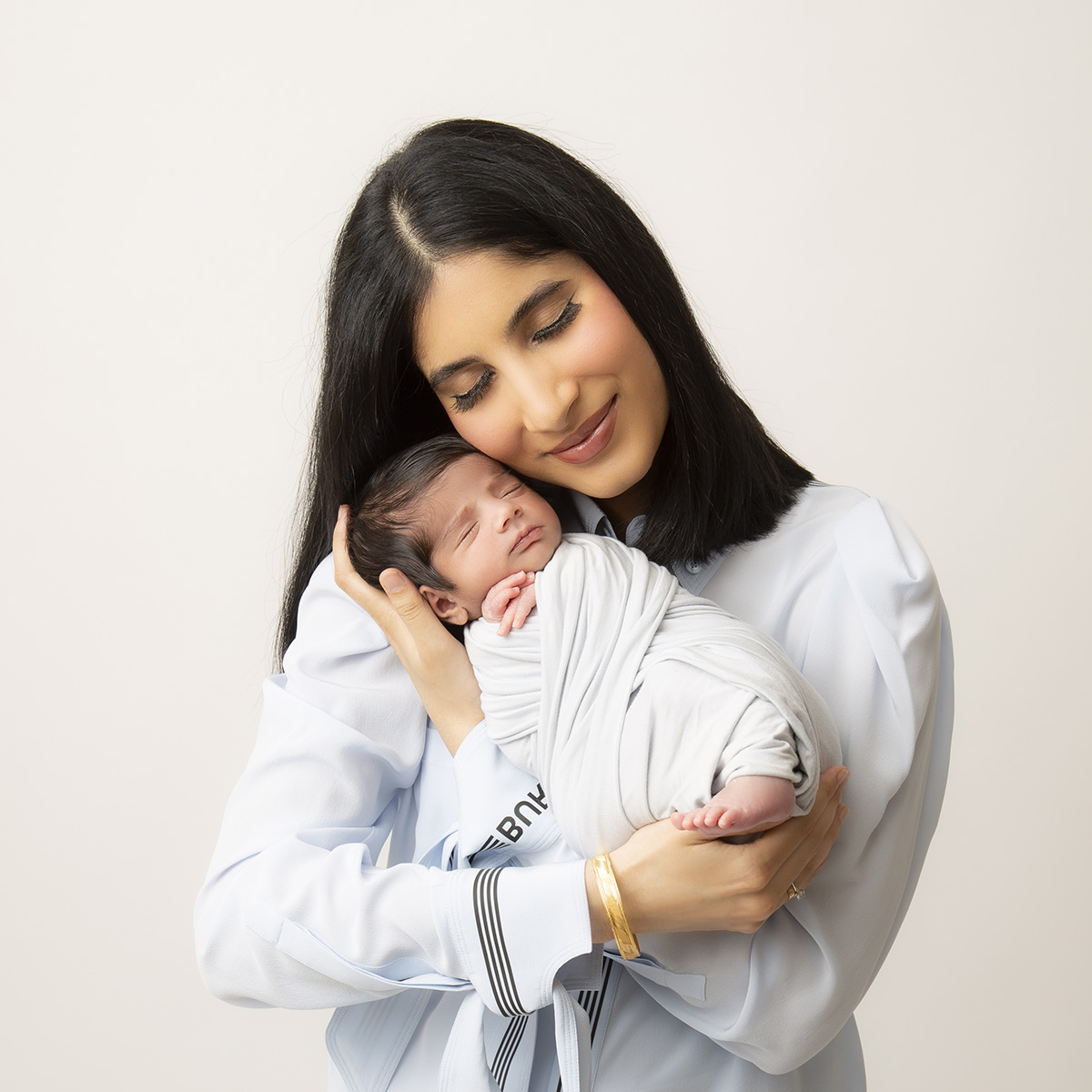 mom holding baby crudle pose newborn photography surrey at artin photography studio