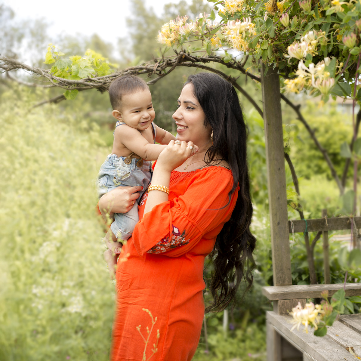 mom holding baby outdoor theme at newborn photography surrey client at artin photography studio